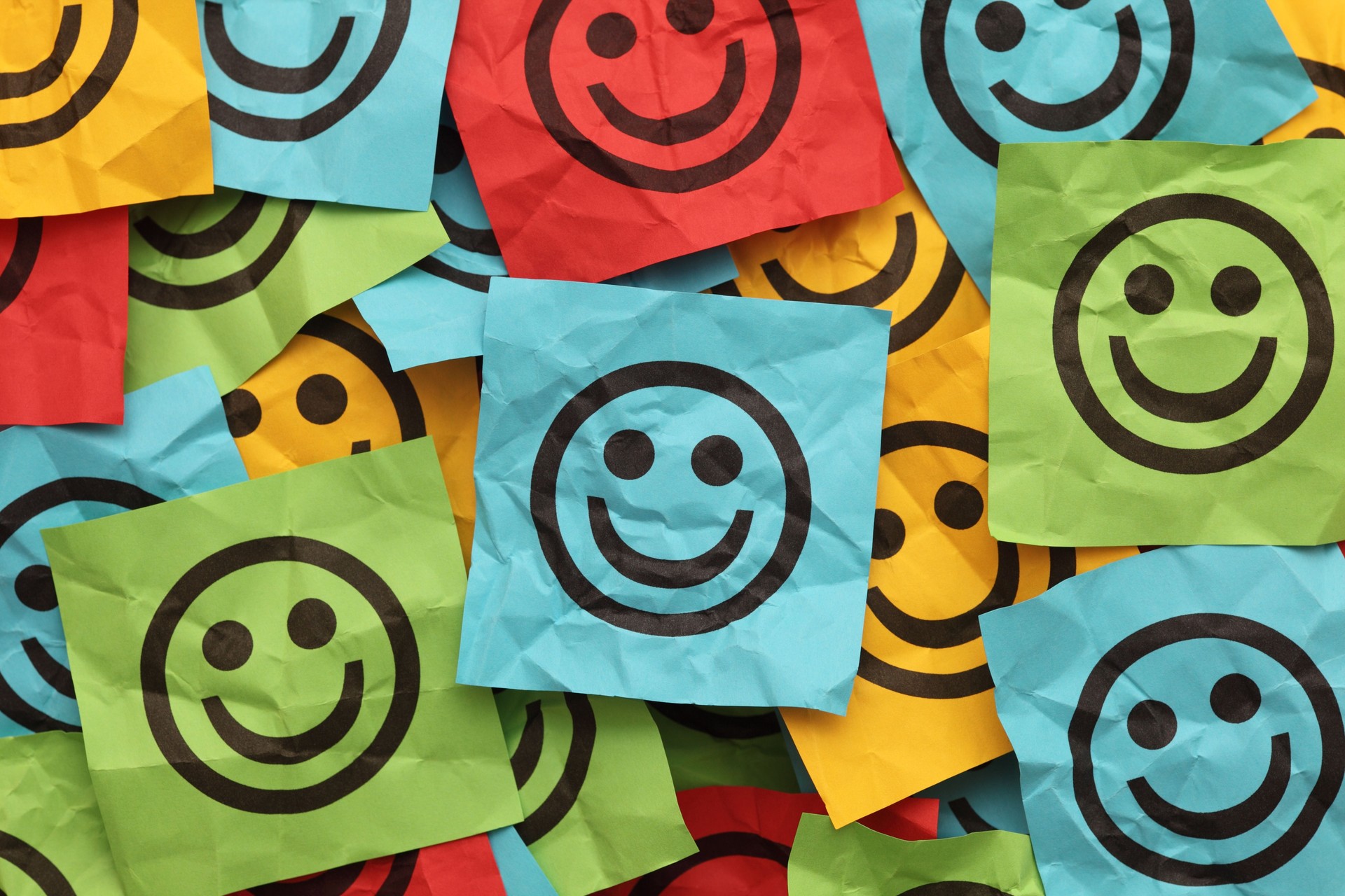 Crumpled adhesive notes with smiling faces